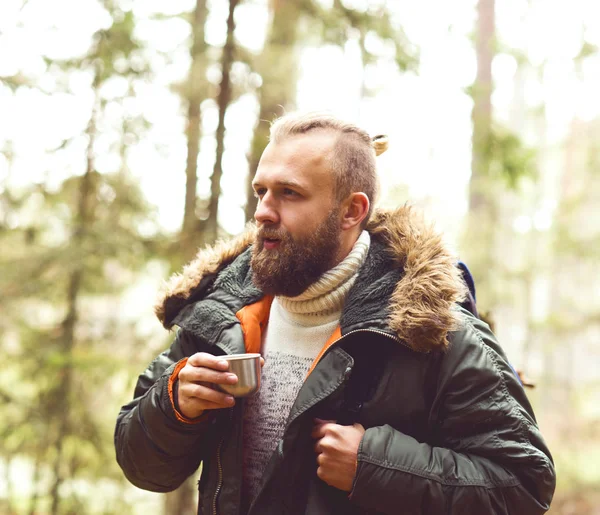 Man with backpack drinking tea from thermos — Stock Photo, Image