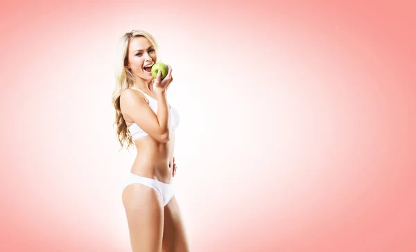 Vrouw in lingerie eten apple — Stockfoto