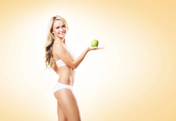 Mulher em lingerie branca com maçã verde — Fotografia de Stock