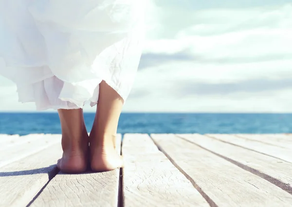 Female legs on wooden pier — Stock Photo, Image