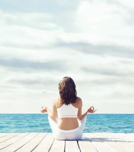 Woman meditating on wooden pier — Stock Photo, Image