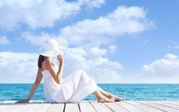 Ahşap iskele üzerinde beyaz elbiseli kadın — Stok fotoğraf
