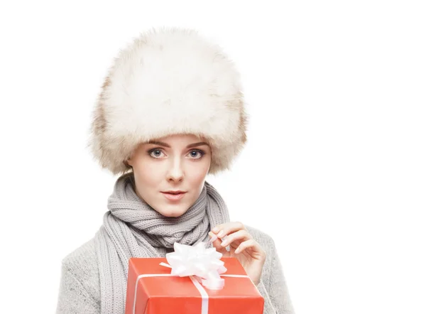 Žena v kožešinové čepice s červeným dárek — Stock fotografie