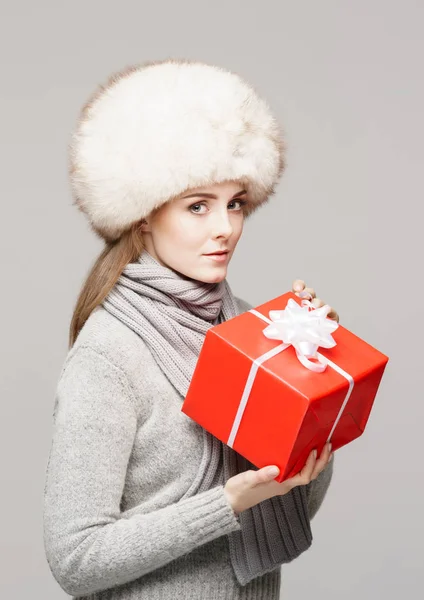 Femme en chapeau de fourrure avec cadeau rouge — Photo