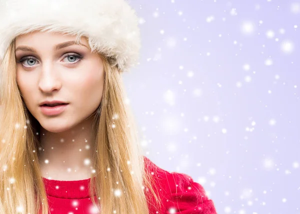 年轻美丽的女孩的画像在圣诞节帽子在冬天背景 免版税图库图片