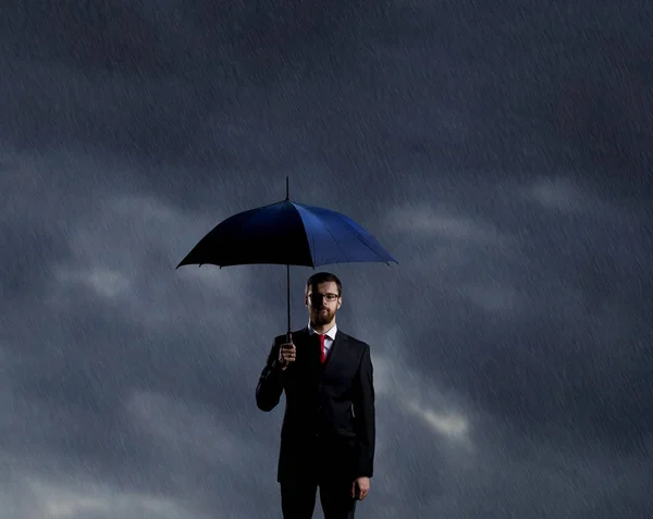 嵐の背景の上に傘立って実業家 ビジネス 危機概念 — ストック写真