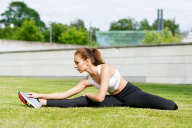 Genç, uygun ve sportif kadın parkta germe. Fitness, spor, kentsel ve sağlıklı yaşam konsepti.