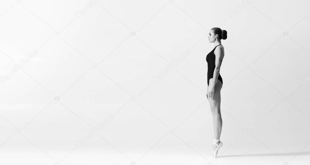 Graceful ballerina dancing in art performance. Young and beautiful ballet dancer in black and white.