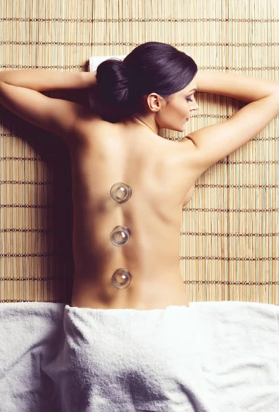 beautiful, young and healthy woman in spa salon is having vacuum cupping. Spa, health and healing concept