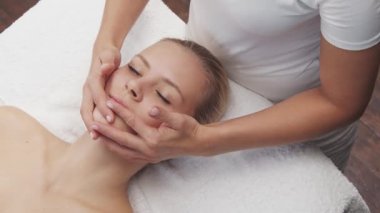 Genç, güzel ve sağlıklı bir kadın spa salonunda. Geleneksel Tayland masaj terapisi ve cilt bakımı.