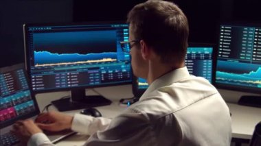 İşyeri ve analiz teknolojisi kullanarak geceleri ofiste çalışan bir tüccar. Borsa, kripto para birimi, küresel iş, finansal ticaret ve bankacılık kavramı.