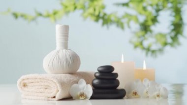 Spa arkaplan kompozisyonu. Havlu, mumlar, çiçekler, taşlar ve bitkisel toplar. Masaj, oryantal terapi, refah ve meditasyon kavramı.