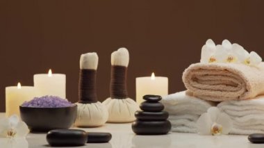 Spa arkaplan kompozisyonu. Havlu, mumlar, çiçekler, taşlar ve bitkisel toplar. Masaj, oryantal terapi, refah ve meditasyon kavramı.