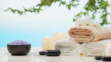 Oryantal masaj tedavisi kompozisyonu. Havlu, mumlar, çiçekler, taşlar ve bitkisel toplar. Spa prosedürleri, meditasyon, refah ve aromaterapi kavramı.