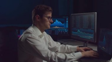 İşyeri ve analiz teknolojisi kullanarak geceleri ofiste çalışan bir tüccar. Borsa, kripto para birimi, küresel iş, finansal ticaret ve bankacılık kavramı.