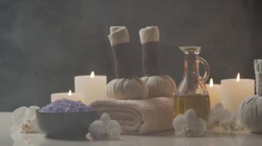 Spa arkaplan kompozisyonu. Havlu, mumlar, çiçekler, taşlar ve bitkisel toplar. Masaj, oryantal terapi, refah ve meditasyon kavramı.
