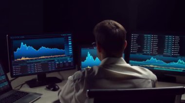 İşyeri ve analiz teknolojisi kullanarak geceleri ofiste çalışan bir tüccar. Borsa, kripto para birimi, küresel iş, finansal ticaret ve bankacılık kavramı.