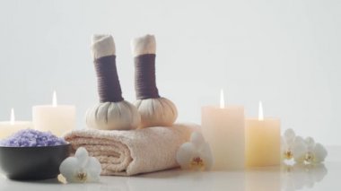 Oryantal masaj tedavisi kompozisyonu. Havlu, mumlar, çiçekler, taşlar ve bitkisel toplar. Spa prosedürleri, meditasyon, refah ve aromaterapi kavramı.