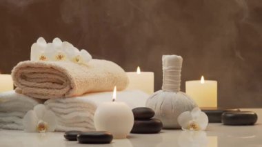 Oryantal masaj tedavisi kompozisyonu. Havlu, mumlar, çiçekler, taşlar ve bitkisel toplar. Spa prosedürleri, meditasyon, refah ve aromaterapi kavramı.