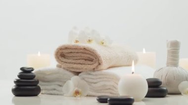 Spa arkaplan kompozisyonu. Havlu, mumlar, çiçekler, taşlar ve bitkisel toplar. Masaj, oryantal terapi, refah ve meditasyon kavramı.