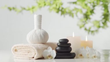 Oryantal masaj tedavisi kompozisyonu. Havlu, mumlar, çiçekler, taşlar ve bitkisel toplar. Spa prosedürleri, meditasyon, refah ve aromaterapi kavramı.