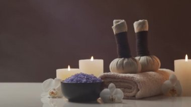 Oryantal masaj tedavisi kompozisyonu. Havlu, mumlar, çiçekler, taşlar ve bitkisel toplar. Spa prosedürleri, meditasyon, refah ve aromaterapi kavramı.