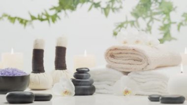 Spa arkaplan kompozisyonu. Havlu, mumlar, çiçekler, taşlar ve bitkisel toplar. Masaj, oryantal terapi, refah ve meditasyon kavramı.