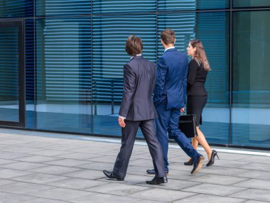Modern ofis binasının önünde konuşan emin işadamlarının. İşadamlarının ve iş kadınının işi var. Bankacılık, profesyonel iş ve finansal piyasa konsepti.