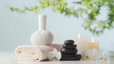 Spa arkaplan kompozisyonu. Havlu, mumlar, çiçekler, taşlar ve bitkisel toplar. Masaj, oryantal terapi, refah ve meditasyon kavramı.