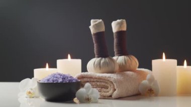 Spa arkaplan kompozisyonu. Havlu, mumlar, çiçekler, taşlar ve bitkisel toplar. Masaj, oryantal terapi, refah ve meditasyon kavramı.