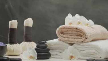 Oryantal masaj tedavisi kompozisyonu. Havlu, mumlar, çiçekler, taşlar ve bitkisel toplar. Spa prosedürleri, meditasyon, refah ve aromaterapi kavramı.
