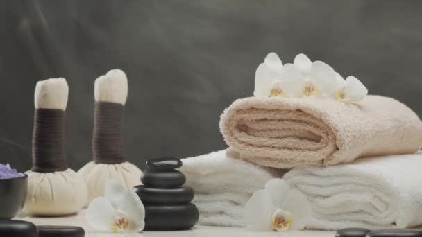 Oosterse Massage Behandeling Samenstelling Handdoek Kaarsen Bloemen Stenen Kruidenballen Spa — Stockvideo