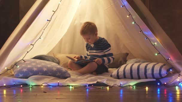 Маленький Хлопчик Грає Читає Казку Дитячому Наметі Вдома Ввечері Щаслива — стокове відео