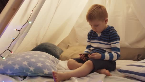 Kleine Jongen Spelen Met Een Smartphone Kindertent Thuis Avond Gelukkig — Stockvideo