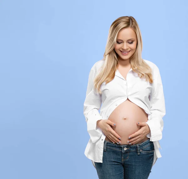 Fiatal Terhes Stúdióban Átöleli Gyönyörű Hasát Kék Háttér Felett Terhesség — Stock Fotó