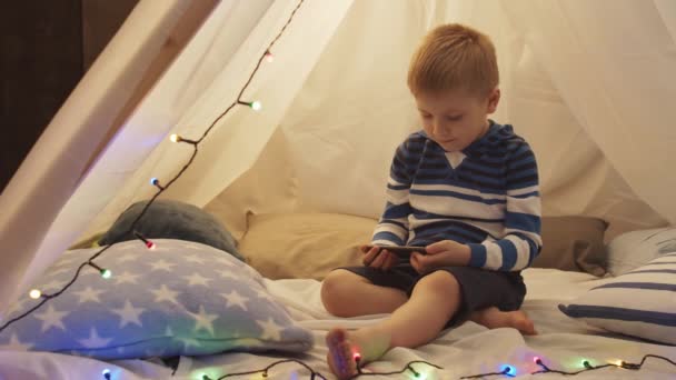 Kleine Jongen Spelen Met Een Smartphone Kindertent Thuis Avond Gelukkig — Stockvideo