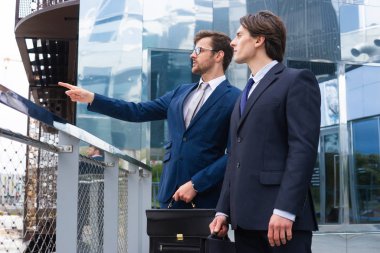 Kendine güvenen iş adamları modern ofis binasının önünde konuşuyorlar. İş adamı ve iş arkadaşı. Bankacılık ve finans piyasası kavramı.