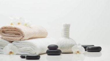 Oryantal masaj tedavisi kompozisyonu. Havlu, mumlar, çiçekler, taşlar ve bitkisel toplar. Spa prosedürleri, meditasyon, refah ve aromaterapi kavramı.