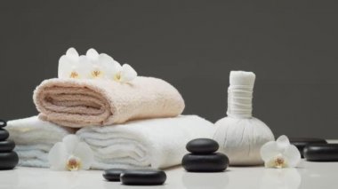 Spa arkaplan kompozisyonu. Havlu, mumlar, çiçekler, taşlar ve bitkisel toplar. Masaj, oryantal terapi, refah ve meditasyon kavramı.
