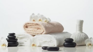 Spa arkaplan kompozisyonu. Havlu, mumlar, çiçekler, taşlar ve bitkisel toplar. Masaj, oryantal terapi, refah ve meditasyon kavramı.