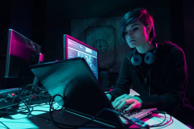 Aranan hackerlar virüs fidye yazılımını bodrumdaki bilgisayar ve dizüstü bilgisayarlarla kodluyorlar. Siber saldırı, sistem kırma ve kötü amaçlı yazılım kavramı.