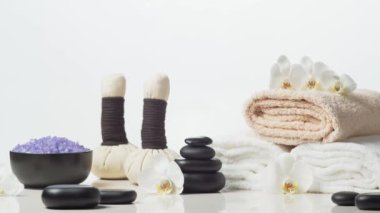 Oryantal masaj tedavisi kompozisyonu. Havlu, mumlar, çiçekler, taşlar ve bitkisel toplar. Spa prosedürleri, meditasyon, refah ve aromaterapi kavramı.