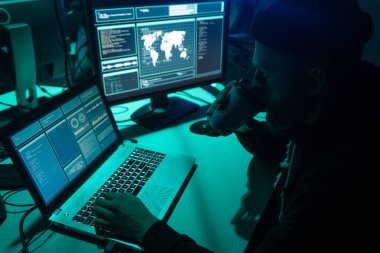 İnternet dolandırıcılığı, darknet, veri hırsızlığı, siber suç konsepti. Hükümet sunucusuna hackerlar saldırdı. Tehlikeli suçlular bodrumda virüs programları kodluyorlar..
