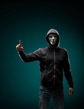 Bilgisayar korsanı beyaz maske ve kapüşonlu portresi. Gizlenmiş karanlık yüzü. Veri hırsız, internet dolandırıcılık, darknet ve siber güvenlik kavramı.