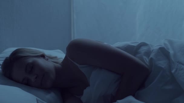 年轻妇女晚上躺在床上 患有失眠病 漂亮的金发睡美人 卧室里的暮色 窗外的月光 健康和休息的概念 — 图库视频影像