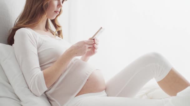 Lycklig Gravid Kvinna Med Hjälp Smartphone Enhet Sitter Sängen Graviditet — Stockvideo