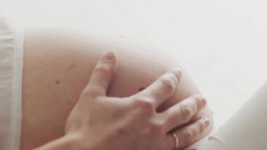 Güzel karnına dokunan hamile kadının yakın çekimi. Hamilelik, annelik ve beklenti konsepti.