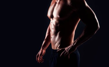 Siyah arka plan üzerinde güçlü, formda ve sporcu bir vücut geliştirici. Spor ve spor konsepti.