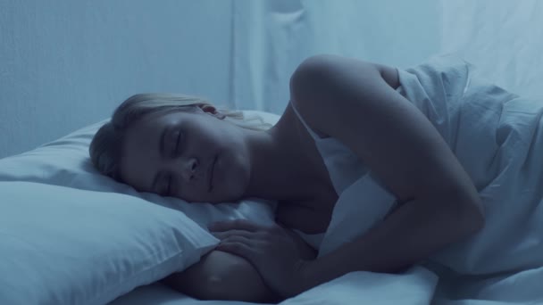 年轻的女人晚上躺在床上 漂亮的金发睡美人 卧室里的暮色 窗外的月光 健康和休息概念 — 图库视频影像