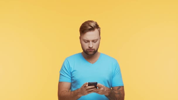 Expressive Young Man Smartphone Vibrant Background Studio Portrait Handsome Person — Stock Video